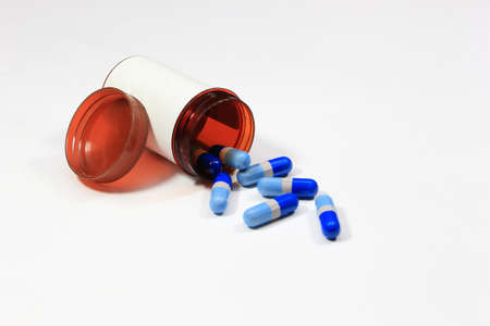 Medicine capsule and white label bottle on white backgroundの写真素材