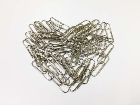 paper clips in a heart shape on white backgroundの写真素材