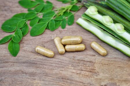 Top view Herbal capsules from moringa herbs on rustic wooden table,background and copy space for using in medical background, healthy eating for good life. Selective focusの写真素材