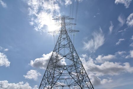 High voltage tower, Electric post and electric cable on the field in the countryside with white...