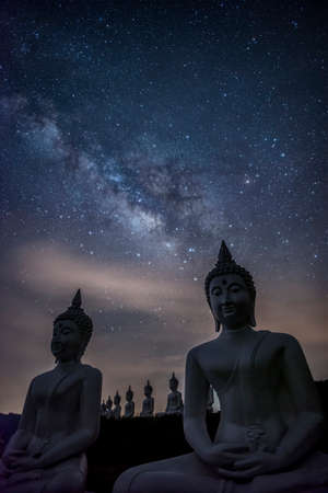 Milky way galaxy over many of buddha statues at Phu Phra Ban Mak Khaeng, Dan Sai, Loei, Thailand. Vertical photoの写真素材