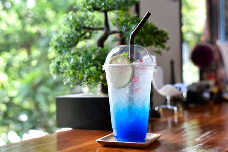 Closeup glass of blue cocktail decorated with lime at bar counter beverage shop background. Cold drinks and cocktails in summer. selected focusの写真素材