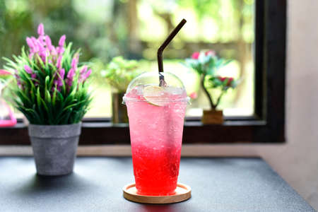 iced red raspberry punch cocktail with lime in glass on bar counter beverage shop background. summer drink. selected focusの写真素材