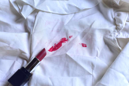 Stains of lipstick or makeup on white clothes or stains on clothes from everyday accidents. Concept of cleaning stains on clothes or cleaning the house. Selected focusの写真素材