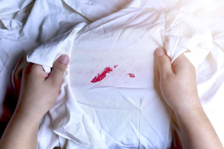 Stains of lipstick or makeup on white clothes or stains on clothes from everyday accidents. Concept...