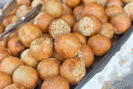 Ball cake swan eggs or kai hong thai dessert. Sesame Ball is fried dessert balls made of flour stuffed with seasoning mung bean, red bean, black bean or peanut paste and coated with white sesame.の写真素材