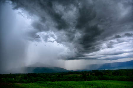 Before a heavy rainstorm, the sky was covered with clouds and strong winds, the dark clouds looked...
