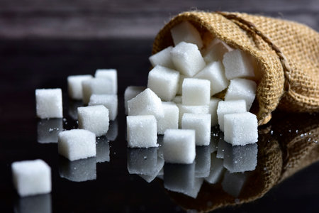 sugar in burlap sack scattered from on a black background.の写真素材