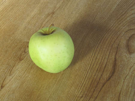 A green apple on a tableの写真素材