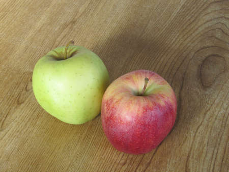 A green and a red apple on a tableの写真素材