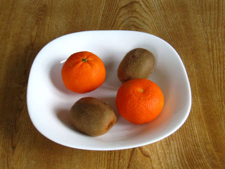 Mandarin oranges and kiwi fruit in a bowlの写真素材
