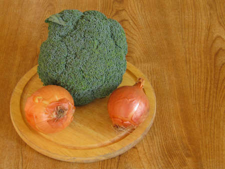 Some broccoli and onions on a table topの写真素材
