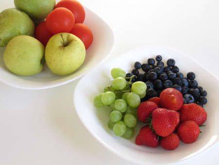 Various fruit displayed in two white bowlsの写真素材