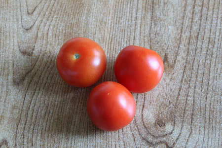 Three tomatoes displayed on a table topの写真素材