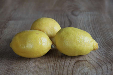 Three lemons in a group left on a table topの写真素材