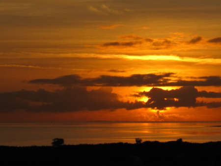 A view of the sun setting on Galway Bay, Ireland.の写真素材