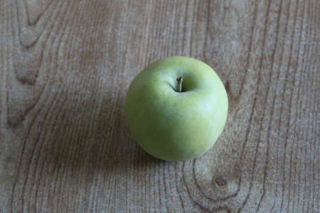 A single green apple displayed on a tableの写真素材