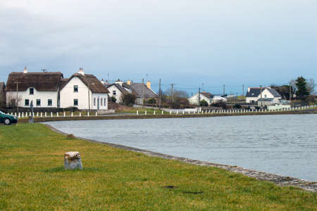 A rural scene with houses beside a riverのeditorial素材