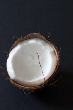 Half a coconut displayed on a dark background