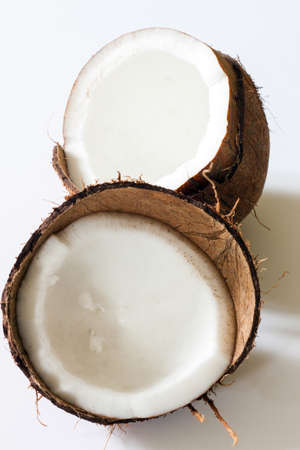 A coconut displayed in two halves on a white backgroundの写真素材