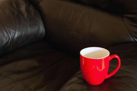 A red cup displayed on an arm chairの写真素材