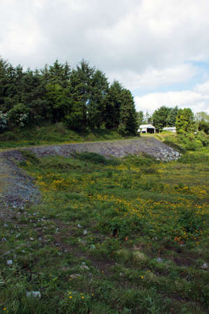A landscape showing a pathway leading to a shed.の写真素材