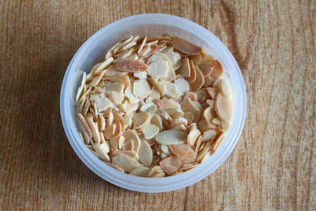 A plastic bowl full of chopped almondsの写真素材