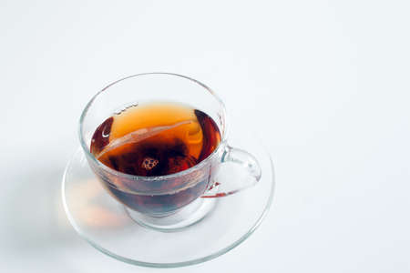 A cup of tea in a transparent cup, with the teabag still in it.の写真素材