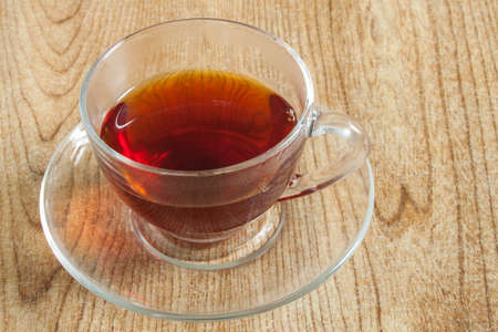 A cup of tea in a transparent cup, displayed on a table top.の写真素材