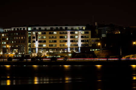 A hotel lit up at night and being reflected in a lake in front of it