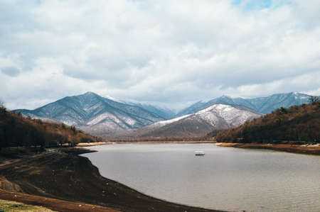 Winter mountain landscape with lake and snow-capped mountains in the backgroundの写真素材