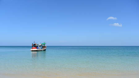 red boat on beach and blue skyの写真素材