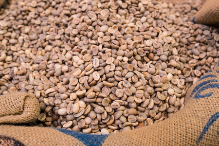 Unroasted coffee beans in sackの写真素材