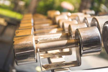 Rows of metal dumbbells on rack in the gym,Weight Training Equipment.の写真素材