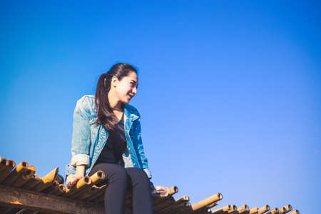 Woman sitting on bridge and blue sky
