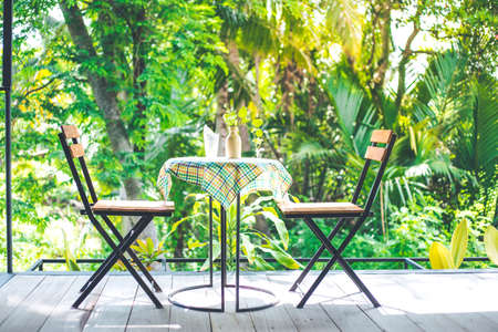 Table and wooden chairs with steel in the coffee shop, table top with colorful tablecloths and vases.の写真素材