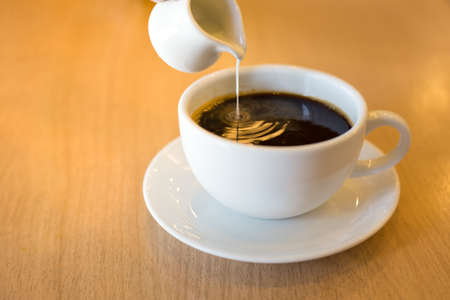 Pouring condensed milk into the coffee.Soft focusの写真素材