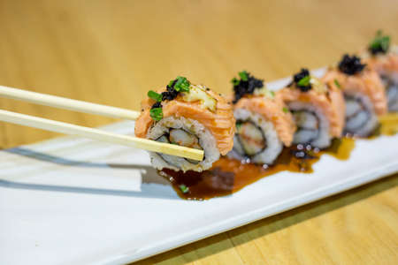 grilled salmon sushi roll on a white plate,japanese food style