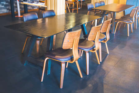 Table and wooden chairs in a modern coffee shop.Soft focusの写真素材