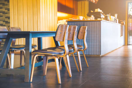 Table and wooden chairs in a modern coffee shop.Soft focusの写真素材