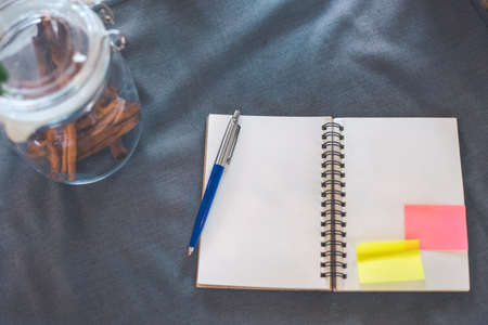 Blank notepad and pen on gray tablecloth.And jarの写真素材
