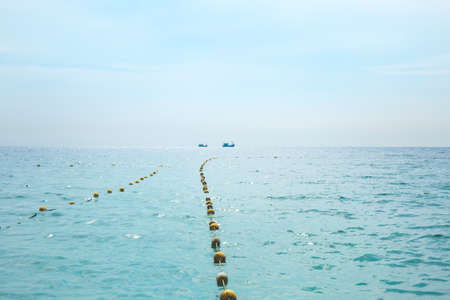 The sea and the sky, along with the fishing boats looking away.の写真素材