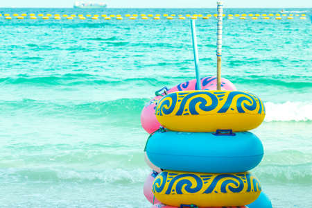 Colorful rubber rings stacked on the beach.