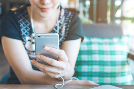 Women hand are listening to music from mobile phones.の写真素材