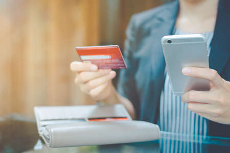 Business women hand use mobile phone to shop online through credit cards.
