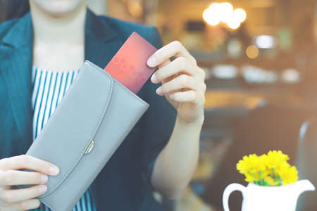 Business women hand are pulling a credit card out of a wallet.の写真素材