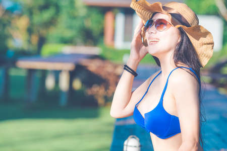Asian woman wearing bikini swimwear on the wooden terrace.の写真素材