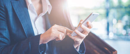 Business women hand are uses a smartphone in office.Web banner.の写真素材