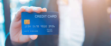 Business woman hand holds a blue credit card.Web banner.の写真素材