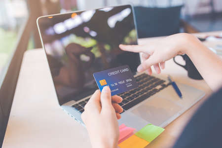 Business women use credit cards and laptop computers to shop online.の写真素材